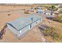 Rear view of a manufactured home showcasing a patio and gravel landscaping at 10991 W Hilltop Dr, Casa Grande, AZ 85193