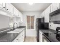 Modern kitchen featuring white cabinets and granite countertops at 14203 N 19Th Ave # 1051, Phoenix, AZ 85023