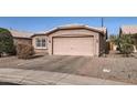 Front view of a tan house with a two-car garage and desert landscaping at 1486 E Augusta Ave, Chandler, AZ 85249