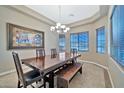 Formal dining room featuring a wood table, bench seating and large artwork at 18672 W Santa Irene Dr, Goodyear, AZ 85338