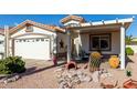 Front view of the house with a covered patio, desert landscaping, and a two-car garage at 2329 N Recker Rd # 94, Mesa, AZ 85215