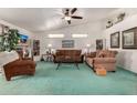 Bright living room with teal carpet, brown sofas, and a large TV at 2329 N Recker Rd # 94, Mesa, AZ 85215