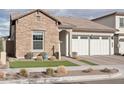 Single-story home with stone exterior, three-car garage, and landscaped front yard at 26123 N 20Th Dr, Phoenix, AZ 85085