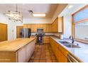 Kitchen with wood cabinets, island, and stainless steel appliances at 6052 N 183Rd Ave, Waddell, AZ 85355