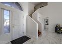 Bright entryway with tiled floor, staircase, and view to living room at 669 S Saddle St, Gilbert, AZ 85233