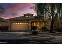 Tan house with a two-car garage, landscaping, and a tree at 7419 S 31St Dr, Phoenix, AZ 85041