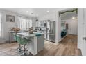 Modern kitchen with island, stainless steel appliances, and teal stools at 7419 S 31St Dr, Phoenix, AZ 85041