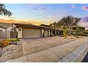 A tan-colored house with a three-car garage and nicely landscaped front yard at 9690 N 117Th Way, Scottsdale, AZ 85259