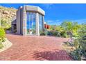 Brick driveway leading to a contemporary home with large windows at 10040 E Happy Valley Rd # 1047, Scottsdale, AZ 85255