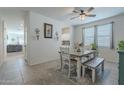 Dining area with a farmhouse table, bench seating, and ceiling fan at 10421 E Cliffrose Ln, Florence, AZ 85132