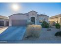 House exterior with a gray garage door and well-maintained landscaping at 10421 E Cliffrose Ln, Florence, AZ 85132