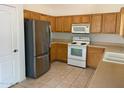Kitchen features wood cabinets, stainless steel appliances, and tile floor at 1120 S 232Nd Ave, Buckeye, AZ 85326