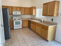 Kitchen boasts wood cabinets, stainless steel appliances, and tile flooring at 1120 S 232Nd Ave, Buckeye, AZ 85326