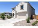 Two-story house with tan exterior, two-car garage, and desert landscaping at 1702 W Flintlock Dr, San Tan Valley, AZ 85144