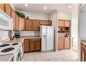 Kitchen with wood cabinets, white appliances, and tile floor at 5450 E Mclellan Rd # 234, Mesa, AZ 85205