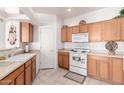 Bright kitchen with wood cabinets, white appliances, and tile floor at 5450 E Mclellan Rd # 234, Mesa, AZ 85205