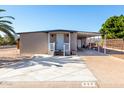 Tan single-wide manufactured home with carport, white railing, and palm tree at 952 S Esperanza Ave, Mesa, AZ 85208