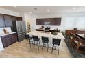 Modern kitchen with island, stainless steel appliances, and dark brown cabinets at 10184 S Bickwell Trl, Apache Junction, AZ 85120