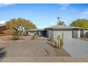 Single story home with gray exterior, landscaping, and a two-car garage at 12424 W Bluestem Dr, Sun City West, AZ 85375