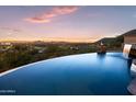 Stunning infinity pool overlooking city lights at sunset at 12950 N 119Th St, Scottsdale, AZ 85259