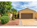 Single-story home with a two-car garage and desert landscaping at 13827 W Junipero Dr, Sun City West, AZ 85375