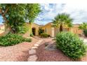 House exterior with a stone walkway and lush landscaping at 13827 W Junipero Dr, Sun City West, AZ 85375