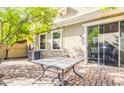 Private backyard patio with brick pavers, table, and mature trees at 1421 N 80Th Ln, Phoenix, AZ 85043