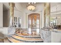 Grand entry with marble floors, elegant columns and a wood door at 14216 S Canyon Dr, Phoenix, AZ 85048