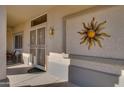 Front door entrance with decorative sun art at 16148 W Sentinel Dr, Sun City West, AZ 85375