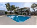 Community swimming pool with surrounding lounge chairs and trees at 16807 E Gunsight Dr # B23, Fountain Hills, AZ 85268