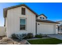 White farmhouse exterior with landscaping and a two-car garage at 17155 W Gracemont St, Surprise, AZ 85388