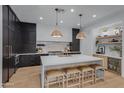 Modern kitchen featuring a large island, dark cabinetry, and high-end appliances at 17708 N 92Nd St, Scottsdale, AZ 85255