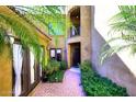 Inviting courtyard entry with a brick path, lush landscaping, and access to the home's interior at 2105 E Kerry Ln, Phoenix, AZ 85024