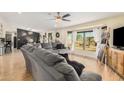 Living room featuring a gray couch, large window, and wood flooring at 22183 N 178Th Ave, Surprise, AZ 85387