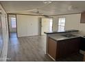 Open kitchen with a breakfast bar, wood cabinets, and grey laminate floors at 2701 E Allred Ave # 110, Mesa, AZ 85204