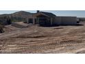 Contemporary home featuring a unique design, large windows, and a desert landscape, still under construction at 3529 S Kings Ranch Ct, Gold Canyon, AZ 85118