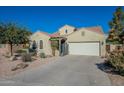 Tan house with a white garage door and desert landscaping at 36080 W Merced St, Maricopa, AZ 85138