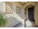 Front entrance with decorative iron wall art and a dark wooden door at 36080 W Merced St, Maricopa, AZ 85138