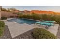 Relaxing pool area with lounge chairs and mountain backdrop at 42405 N Anthem Creek Dr, Anthem, AZ 85086