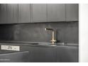 Close-up of a kitchen sink with a modern gold faucet and Miele dishwasher at 4825 N 72Nd Way, Scottsdale, AZ 85251