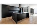 Modern kitchen with sleek black cabinetry, large island, and high-end appliances at 4825 N 72Nd Way, Scottsdale, AZ 85251