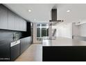 Modern kitchen with sleek black cabinetry, large island, and high-end appliances at 4825 N 72Nd Way, Scottsdale, AZ 85251