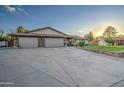 Three-car garage home with a large driveway and manicured lawn at 5133 W Monte Cristo Ave, Glendale, AZ 85306