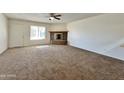 Bright living room featuring a brick fireplace and ceiling fan at 8738 W Tinajas Dr, Arizona City, AZ 85123