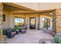 Inviting front porch with comfortable seating, decorative vases, and stone accents creating a warm entry at 10567 E Mark Ln, Scottsdale, AZ 85262