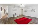 Spacious living room featuring wood-look floors and a red rug at 10826 N 115Th Ave, Youngtown, AZ 85363