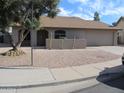 Tan one-story house with a brown roof, two-car garage, and gravel driveway at 1305 W Isabella Ave, Mesa, AZ 85202