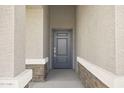 Gray front door entryway with stone accents at 15374 W Hackamore Dr, Surprise, AZ 85387