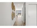 Bright hallway with wood floors and modern wall art leading to the living area at 15382 W Hackamore Dr, Surprise, AZ 85387