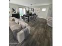 Open concept living and dining area with modern furnishings and hardwood floors at 16405 W Latham St, Goodyear, AZ 85338